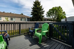 Outdoor deck with composite wood-finish flooring, dark-stained wooden railings, and a gate - 