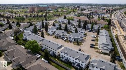 Aerial perspective of a multi-unit residential development with light-colored siding and dark-shingled roofs - 