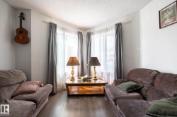 Living area featuring wood-finish flooring, white walls, and crown molding - 
