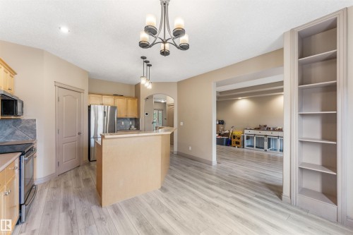 Kitchen with wood-finish flooring, light wood cabinetry, stainless steel appliances, and a tiled backsplash - 35 Oakridge Dr, St. Albert, AB - Indoor Photo Showing Kitchen