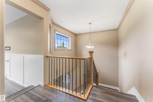 Staircase featuring wood-finish flooring, wood handrails, and black metal balusters - 35 Oakridge Dr, St. Albert, AB - Indoor Photo Showing Other Room