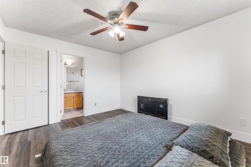 Bedroom featuring wood-finish flooring, a ceiling fan with integrated lighting, and white baseboards - 35 Oakridge Dr, St. Albert, AB - Indoor Photo Showing Bedroom