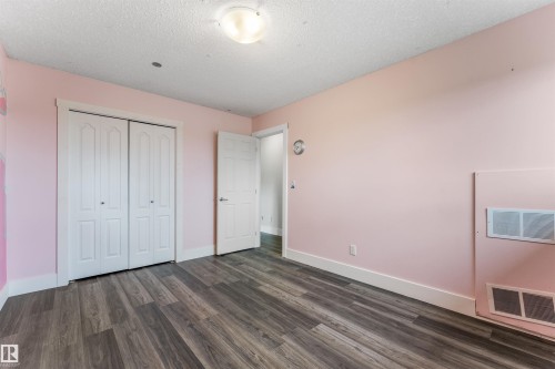 Room featuring wood-finish flooring, white baseboards, and a bi-fold closet - 35 Oakridge Dr, St. Albert, AB - Indoor Photo Showing Other Room