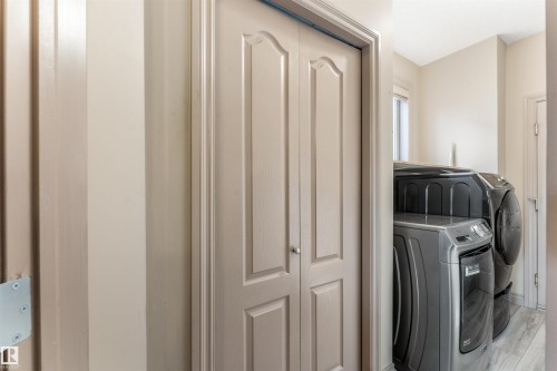 Laundry area featuring bi-fold doors, neutral wall paint, and a window for natural light - 35 Oakridge Dr, St. Albert, AB - Indoor Photo Showing Laundry Room