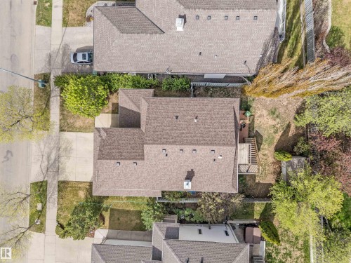 Asphalt shingle roofing, paved driveway, mature trees, and a rear wood deck - 35 Oakridge Dr, St. Albert, AB - Outdoor With Deck Patio Veranda