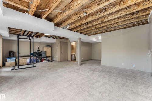 Expansive carpeted area with a partially finished ceiling featuring exposed joists - 35 Oakridge Dr, St. Albert, AB - Indoor Photo Showing Basement