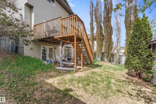 Rear exterior featuring a wooden deck with railing, stairs, and a ground-level patio - 35 Oakridge Dr, St. Albert, AB - Outdoor With Deck Patio Veranda