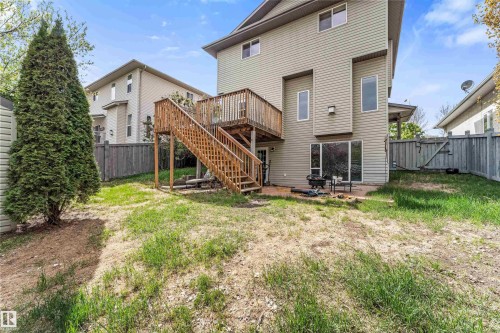 Rear exterior featuring a wood deck with stairs, a ground-level patio, and a sliding glass door - 35 Oakridge Dr, St. Albert, AB - Outdoor