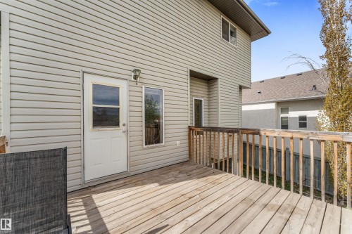 Expansive wood-finish deck with a wood railing, exterior siding, and a white access door - 35 Oakridge Dr, St. Albert, AB - Outdoor With Deck Patio Veranda With Exterior