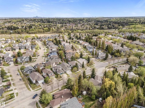 Residential neighborhood featuring a variety of detached homes with distinct architectural styles, mature trees lining the streets, and a distant city skyline - 35 Oakridge Dr, St. Albert, AB - Outdoor With View