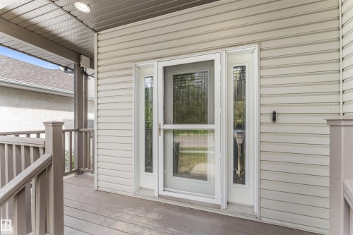 Covered porch with wood-finish decking and railing - 35 Oakridge Dr, St. Albert, AB - Outdoor With Deck Patio Veranda With Exterior