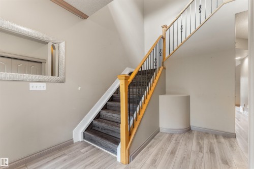 Central staircase featuring wood-finish treads and risers, wrought iron balusters, and a light wood-finish handrail - 35 Oakridge Dr, St. Albert, AB - Indoor Photo Showing Other Room