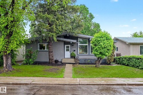 Contemporary facade featuring gray siding and a white entry door - 12115 40 Avenue Nw, Edmonton, AB 