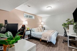 Spacious room featuring wood-finish flooring, neutral wall tones, and a window with blinds - 