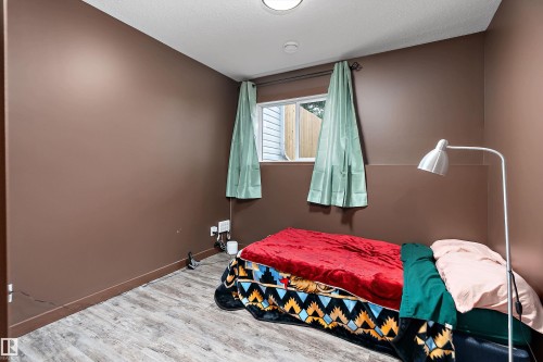 Compact room featuring wood-finish flooring and a single window with blinds - 5210 55 Avenue, Wetaskiwin, AB 