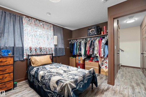 Room featuring wood-finish flooring, a window with natural light, and a built-in open closet system - 5210 55 Avenue, Wetaskiwin, AB 