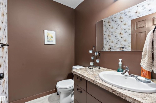 Bathroom featuring a vanity with an integrated sink, laminate countertop, and brown cabinetry - 5210 55 Avenue, Wetaskiwin, AB 