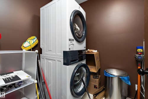 Dedicated laundry space featuring a stacked washer and dryer unit - 5210 55 Avenue, Wetaskiwin, AB 