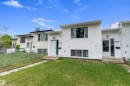 White vinyl siding exterior with multiple windows, concrete steps, and a turfed front yard - 5210 55 Avenue, Wetaskiwin, AB 