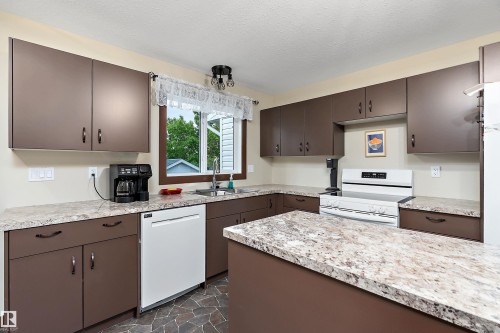 Kitchen with dark brown cabinetry and light-toned countertops - 5210 55 Avenue, Wetaskiwin, AB 