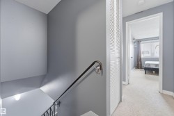 Upper-level hallway featuring light gray walls and plush carpeting - 