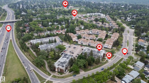 Aerial overview showcasing multi-story residential buildings, surface parking areas, and mature tree landscaping - #110 7805 159 St Nw, Edmonton, AB 