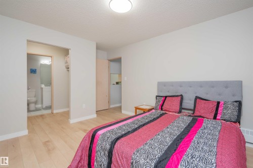 Bedroom featuring light wood-finish flooring, a neutral wall palette, and a semi-flush mount ceiling light - 108 2508 50 Street, Edmonton, AB 