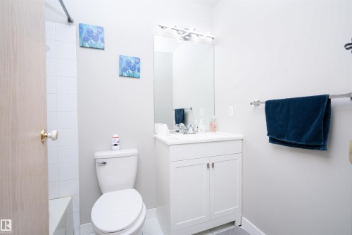 Contemporary bathroom with a white vanity, integrated sink, and chrome faucet - 108 2508 50 Street, Edmonton, AB 