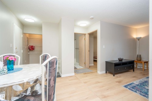 Light wood-finish flooring throughout the main living area, complemented by neutral wall tones - 108 2508 50 Street, Edmonton, AB 