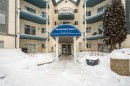 Main entrance to a multi-story building featuring a prominent blue awning - 108 2508 50 Street, Edmonton, AB 