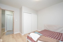 Bedroom featuring light wood-finish flooring, white baseboards, and a neutral wall color - 