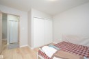 Bedroom featuring light wood-finish flooring, white baseboards, and a neutral wall color - 108 2508 50 Street, Edmonton, AB 
