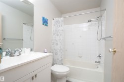 Bathroom featuring a full vanity with an integrated sink, chrome faucet, and a large mirror - 