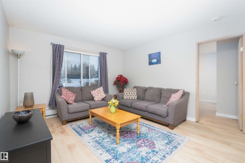 Living area featuring light wood-finish flooring and neutral wall tones - 108 2508 50 Street, Edmonton, AB 