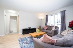 Bright living area featuring light wood-finish flooring and a sliding glass door - 