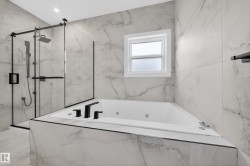 Sleek bathroom featuring a built-in soaking tub with matte black fixtures, a walk-in shower with a glass enclosure and black trim, and large format marble-look tile on the walls and floor - 
