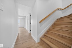 Light wood-finish staircase with coordinating handrail and light-toned carpet runner - 