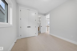 Light-filled room featuring neutral-toned carpet flooring, white walls, and bright white trim - 