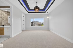 Tray ceiling with accent lighting and a central decorative pendant fixture - 