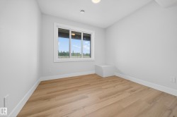 Bright room featuring wood-finish flooring, white baseboards, and a large window - 