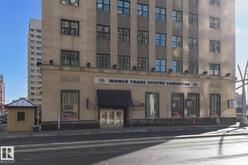 Stone-clad high-rise commercial building featuring a prominent street-level entrance - 411 10024 Jasper Avenue, Edmonton, AB 