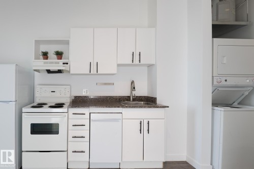 Kitchenette featuring white cabinetry, a white refrigerator, a white electric range, and a dishwasher - 910 10024 Jasper Avenue, Edmonton, AB 