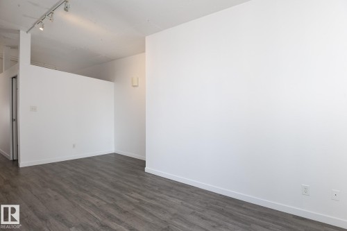 Open concept interior with wood-finish flooring and white walls - 910 10024 Jasper Avenue, Edmonton, AB 