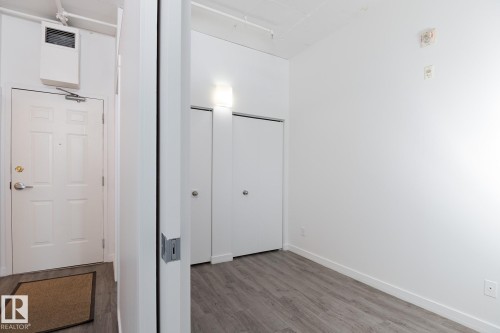 White paneled entry door with brass hardware and overhead wall heater - 910 10024 Jasper Avenue, Edmonton, AB 