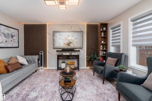 Living area featuring a textured accent wall with integrated backlighting, a marble-look panel, and a built-in corner shelving unit - 9468 209 St, Edmonton, AB 