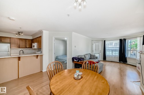 Open-concept living space with light wood-finish flooring - 214 9938 104 Street, Edmonton, AB 