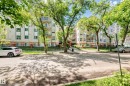 Multi-story building exterior featuring a light-colored facade with numerous windows and balconies - 214 9938 104 Street, Edmonton, AB 