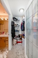Walk-in closet featuring wire shelving, overhead lighting, and frosted glass paneled door - 