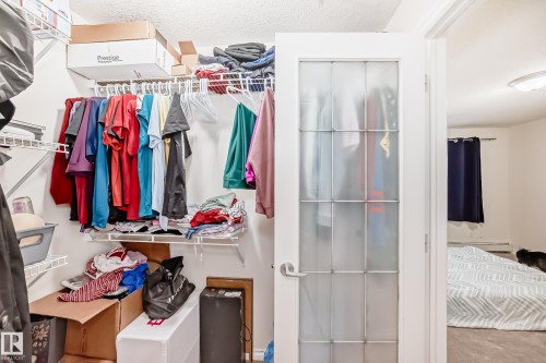 Walk-in closet featuring wire shelving and hanging rods - 214 9938 104 Street, Edmonton, AB 