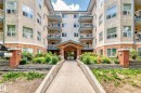 Melrose Manor apartment building featuring a stucco exterior with brick accents, multiple private balconies, and a covered main entrance - 214 9938 104 Street, Edmonton, AB 